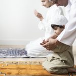 Muslim boy learning how to make Dua to Allah
